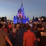 Guests walking toward Cinderella Castle during a summer evening at Walt Disney World.